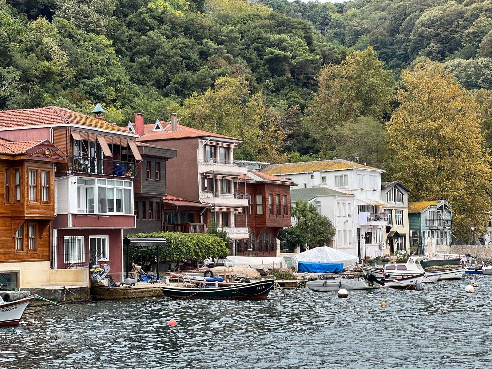 Colorful traditional waterfront houses and fishing boats line the shore at Anadolu Kavagi.