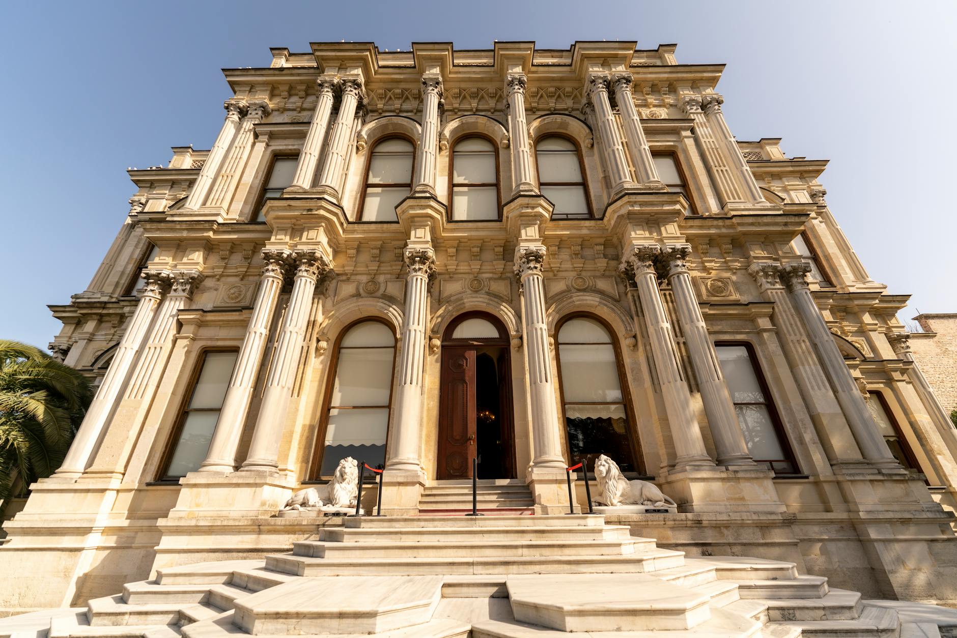 The grand marble entrance of Beylerbeyi Palace features impressive columns and white lion statues.