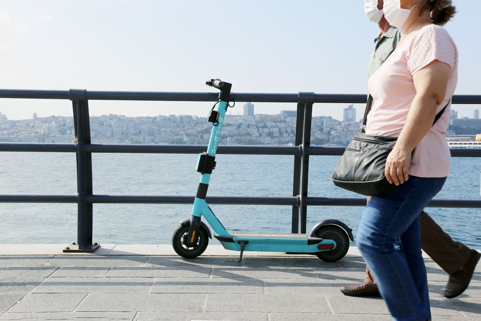 A blue shared electric scooter parked along the Bosphorus waterfront in Istanbul.