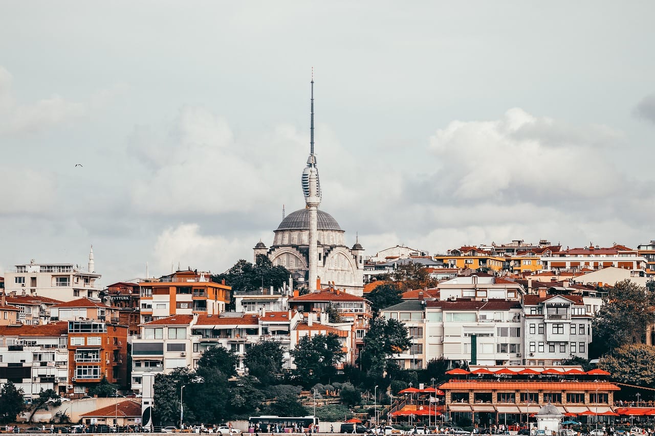 Futuristic Çamlıca Tower standing tall behind a historic Ottoman mosque dome.