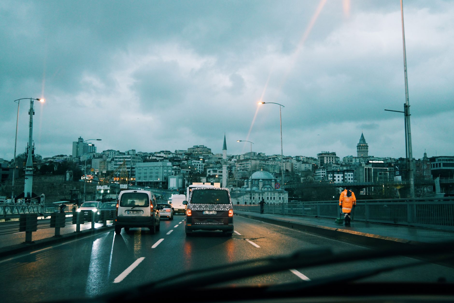 Driver view of urban traffic crossing a wet bridge in Istanbul.
