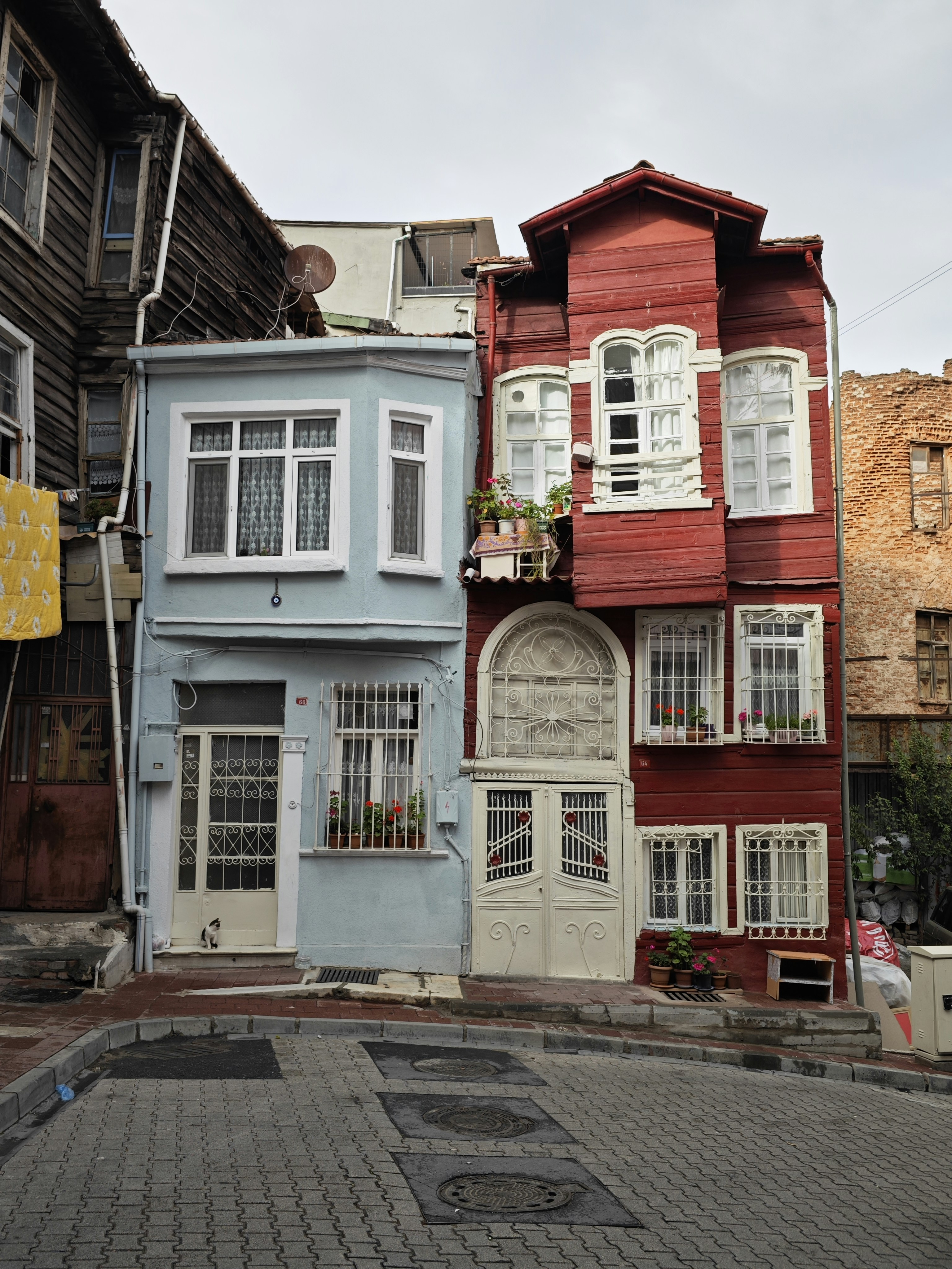 Brightly painted colourful houses lining a steep cobblestone street in the Balat neighbourhood of Istanbul.