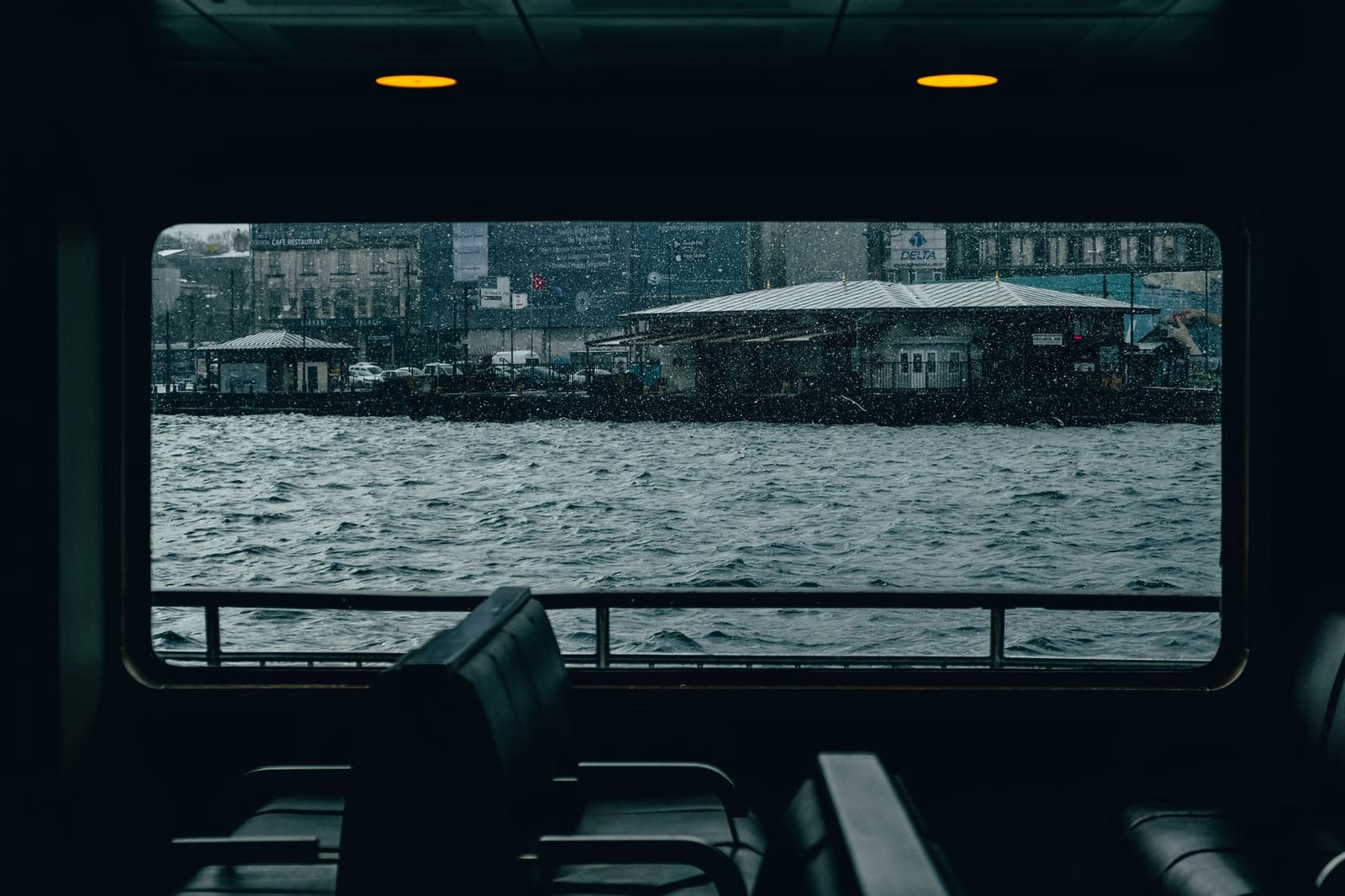 Rain drops on a ferry cabin window looking out at the Istanbul waterfront.