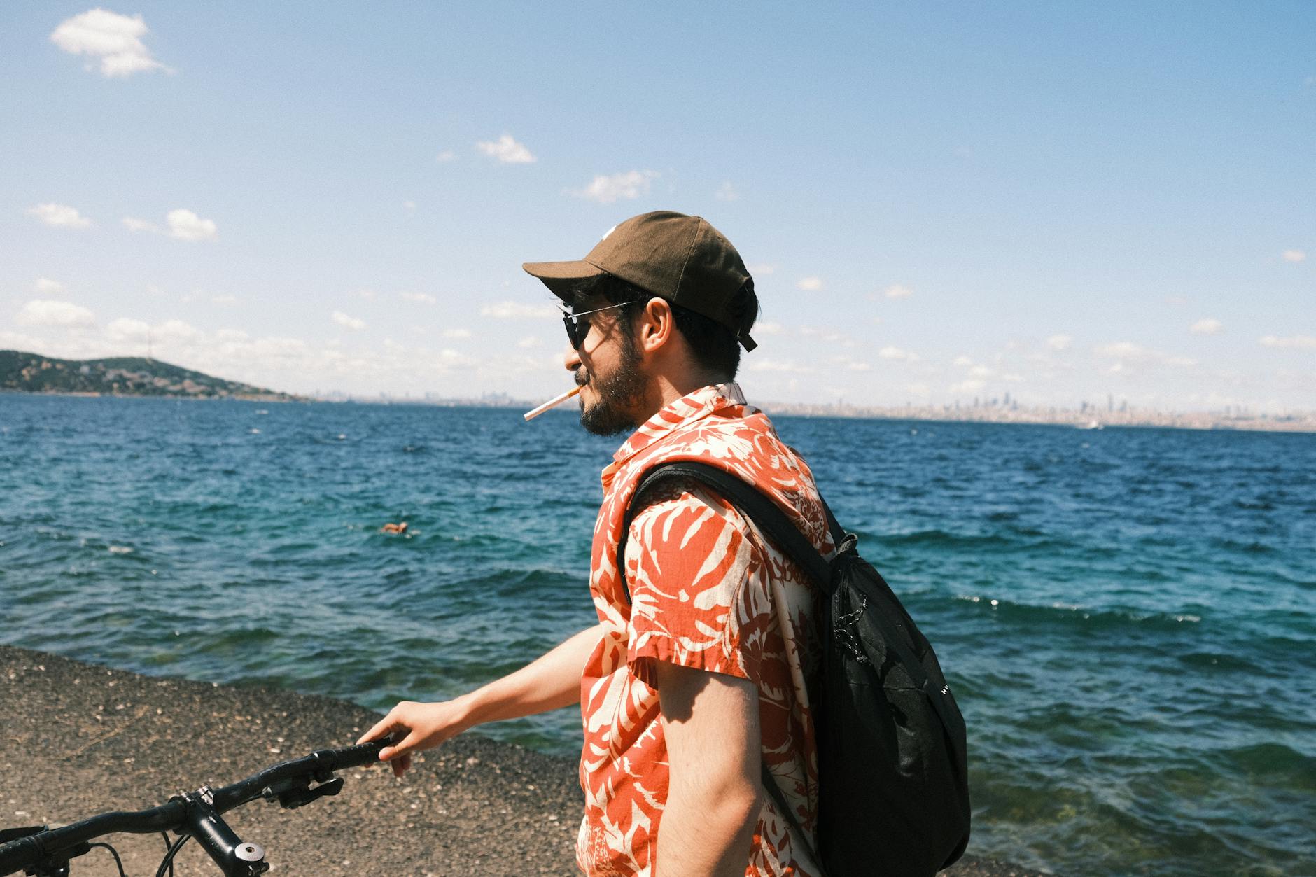 A man with a bicycle overlooks the sea along an Istanbul cycling path.