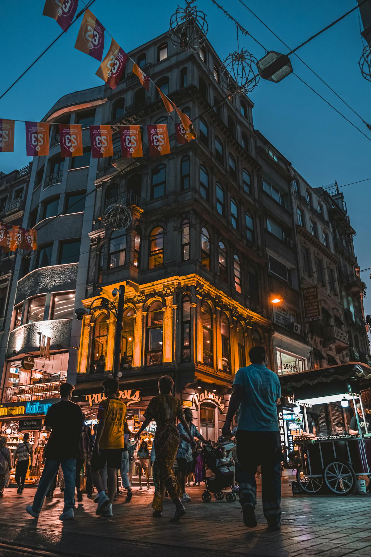 People walking on an illuminated Istanbul street at night, showcasing a safe and bustling urban atmosphere.