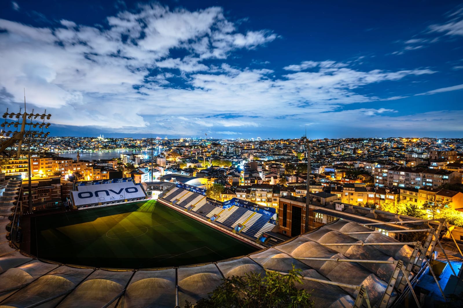 Illuminated Kasimpasa football stadium set against the Istanbul night skyline.