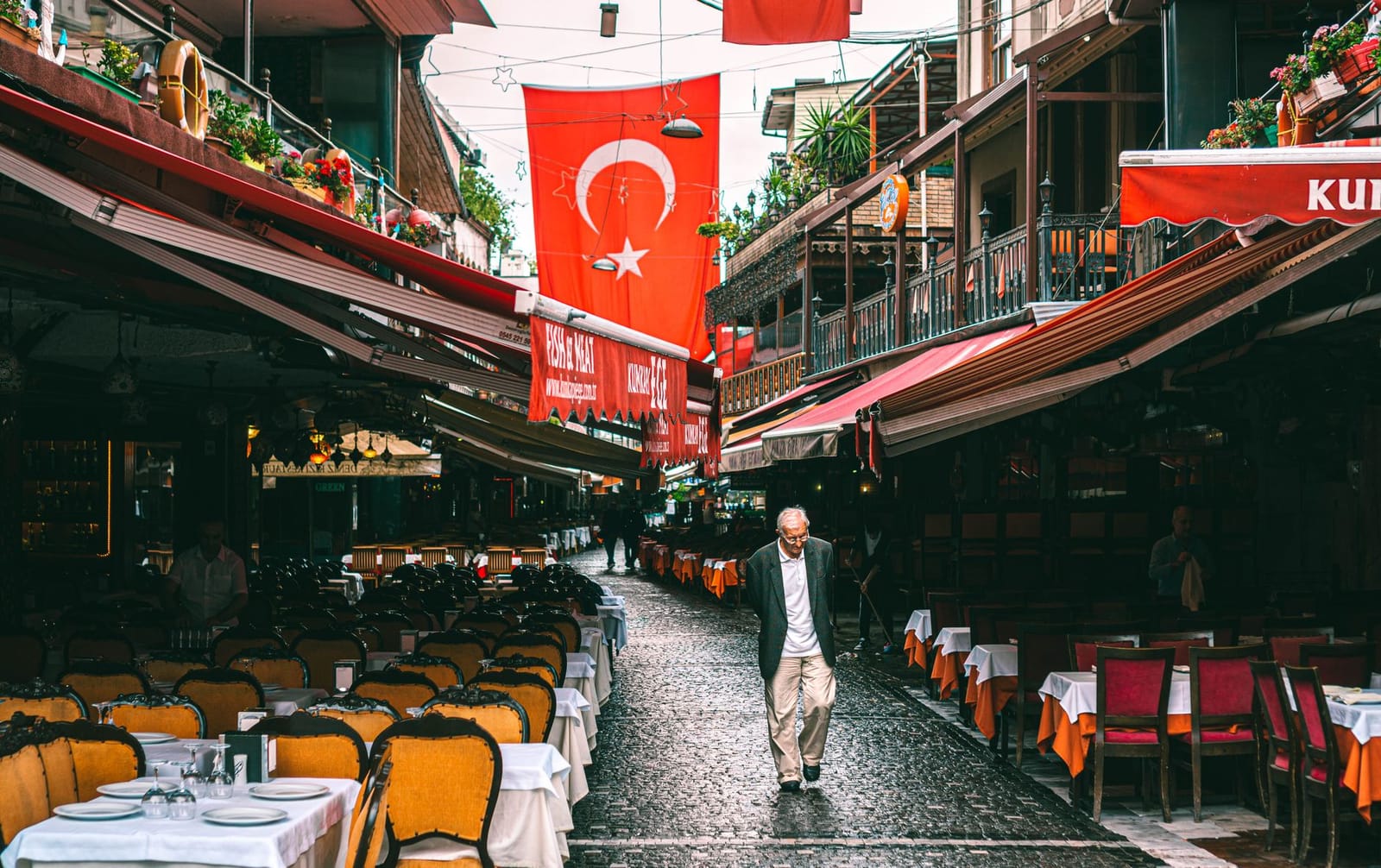 A man walks past outdoor dining tables in Kumkapi's famous dining quarter.