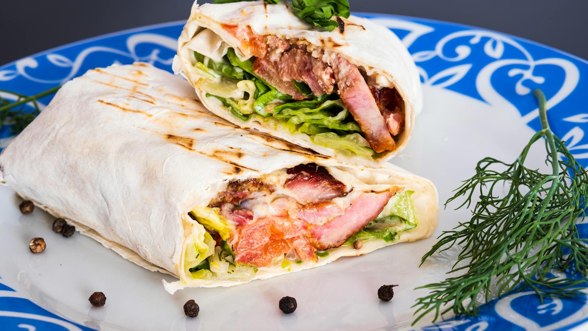 A sliced Niğde style söğüş wrap served on a blue patterned plate in Istanbul.