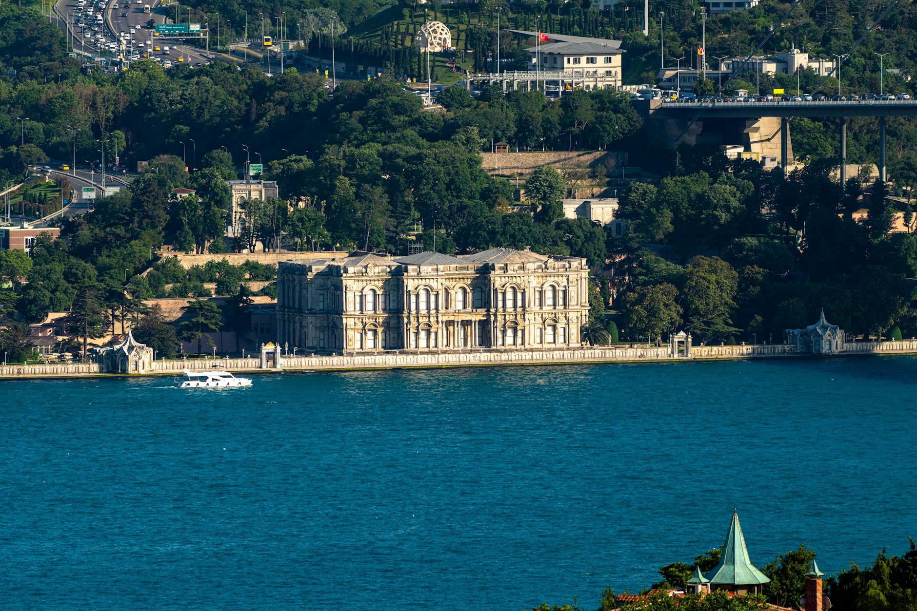 A wide panoramic shot shows the grand Beylerbeyi Palace along the Bosphorus Strait shoreline.