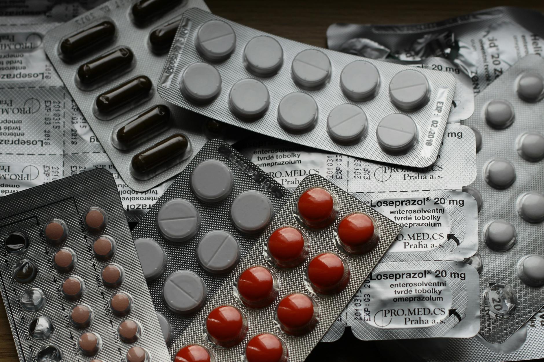 A collection of various blister packs containing different types of common medicine tablets.