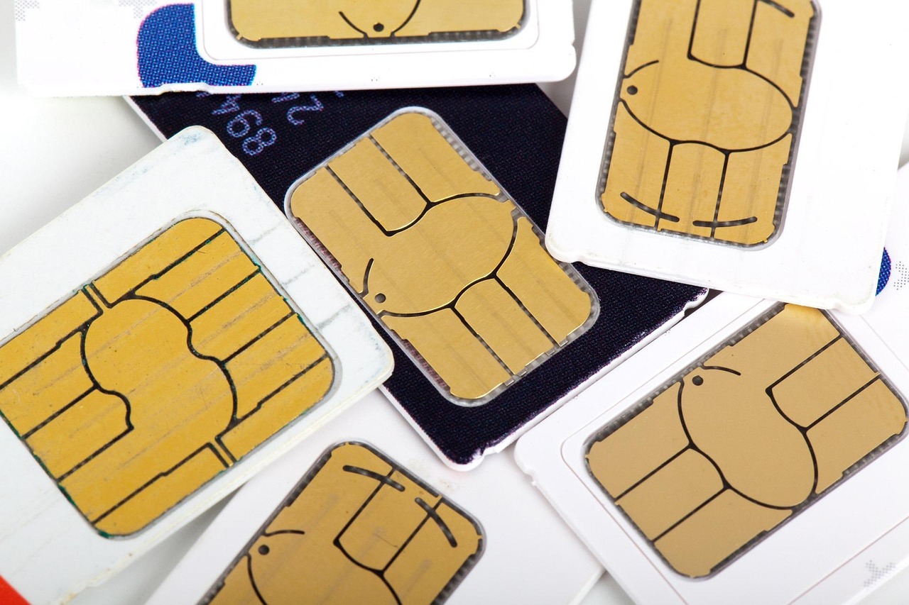 A collection of various mobile SIM cards are scattered across a white background.