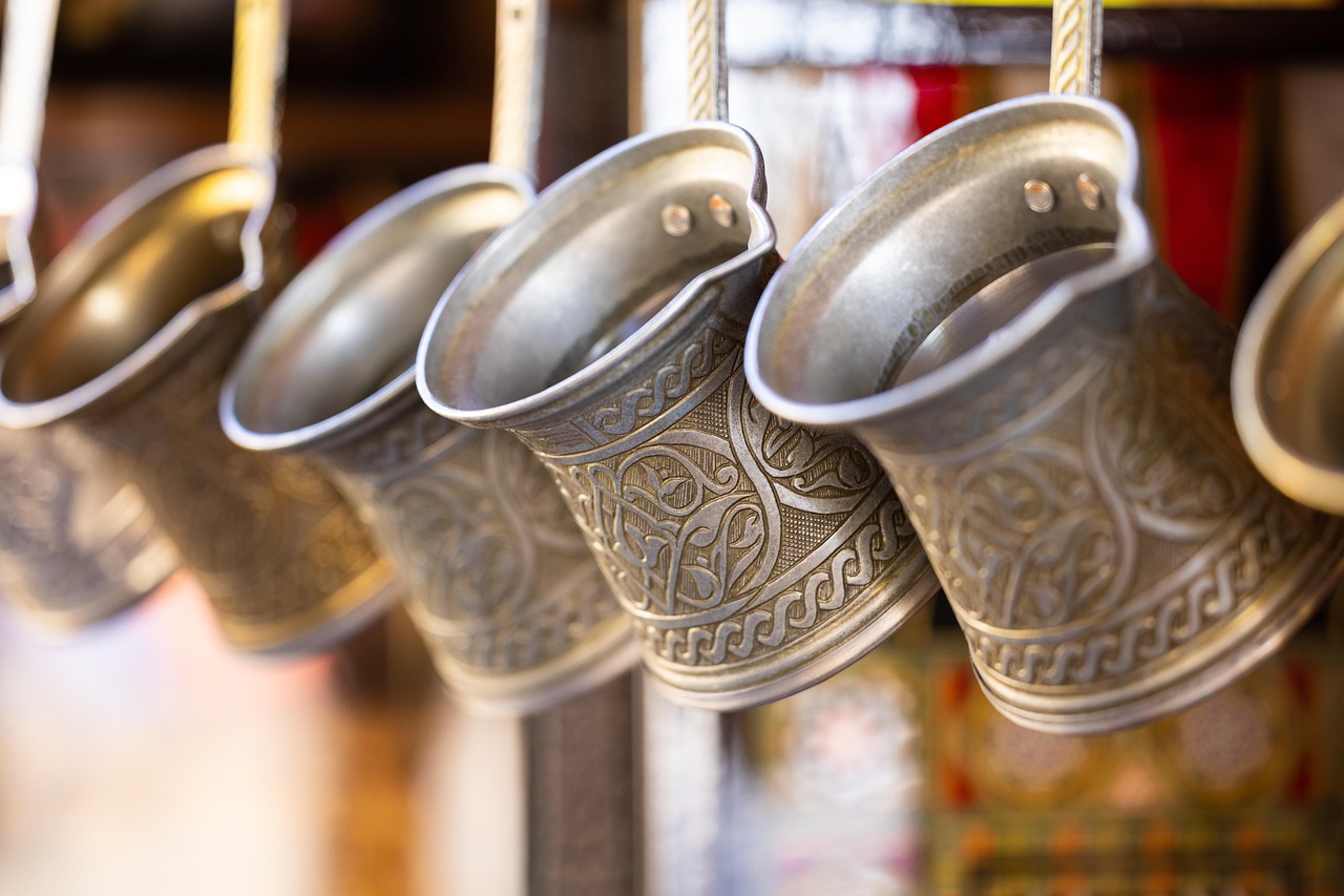 Close-up of traditional metallic Turkish coffee pots hanging in a local shop.