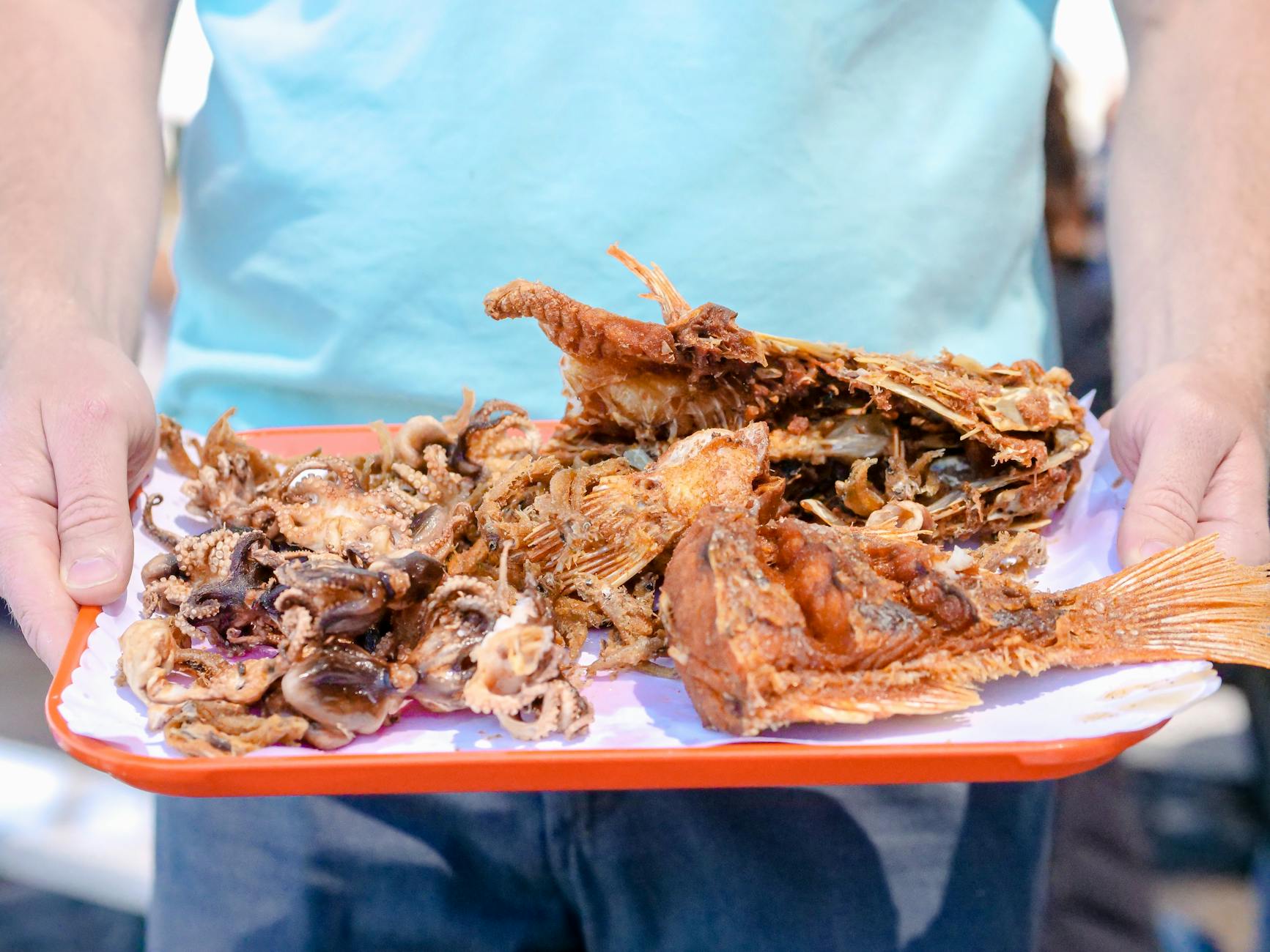 A variety of golden fried seasonal fish and calamari served on a tray.